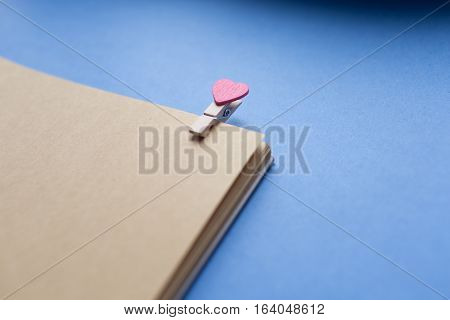 Clothespins with hearts are Notepad. Background is blue paper