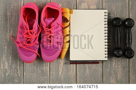 Trainers, dumbbells, ribbon, mat on floor. Stock photo Sporty mock up