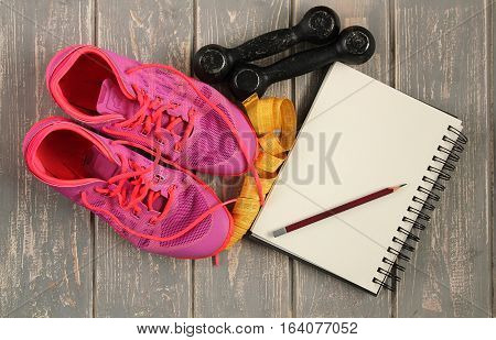 Trainers, dumbbells, ribbon, mat on floor. Stock photo Sporty mock up