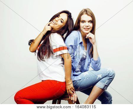 best friends teenage girls together having fun, posing emotional on white background, besties happy smiling, lifestyle people concept, blond and brunette multi nations close up