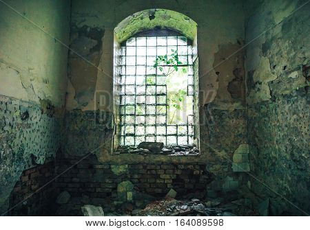 broken window in an old abandoned mansion with peeling walls