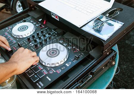 ATLANTA, GA - OCTOBER 2016:  A deejay adjusts the knobs on sophisticated sound equipment to enhance the audio and play rap music at the Atlanta Hip Hop Day a free event open to the public in Woodruff Park in Atlanta GA on October 8 2016.
