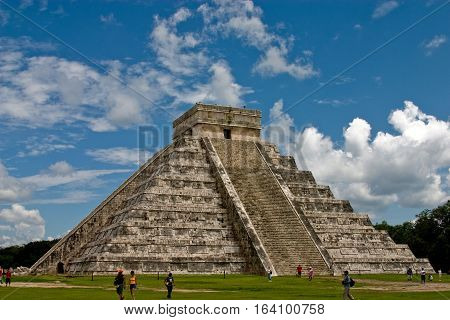 The Great Pyramid at Chichen Itza against blue skies with clouds.