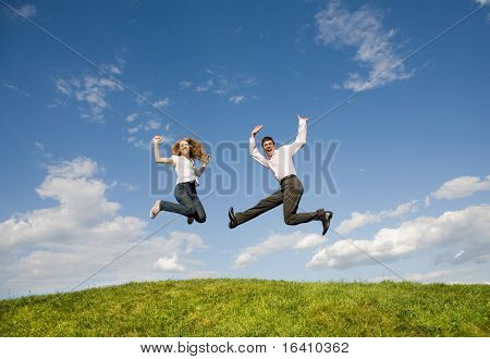 Happy smilende par hoppe i blå himmel