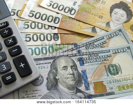 US one hundred dollar and Korean won currency with calculator. Finance business concept.