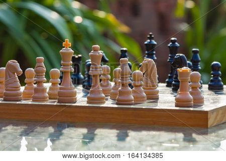 Chess board on the table in a green garden