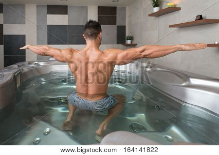 Man Flexing Muscles In Jacuzzi Spa