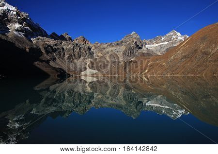 Autumn scene in the Everest National Park. View of the Renjo La mountain pass. Mirroring in Gokyo lake.