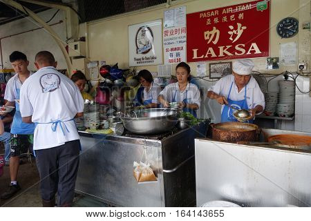 Hawker Vendor At Their Assam Laksa Noodle Stall In Air Itam, Penang
