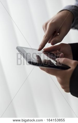 Detail of two business people analyzing data on a tablet computer