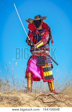 Samurai with sword on the sand. Men in samurai armour on the sand. Original Character