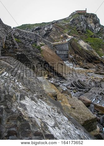 Gastelugache -  island on  coast of  Bay of Biscay belonging to  municipality of Bermeo, Basque Country.  Island is connected to  mainland by  man-made bridge that goes into  winding staircase that spans 237 degrees.