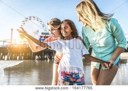 Lesbians mothers with adopted child - Happy homosexual family playing with her daughter