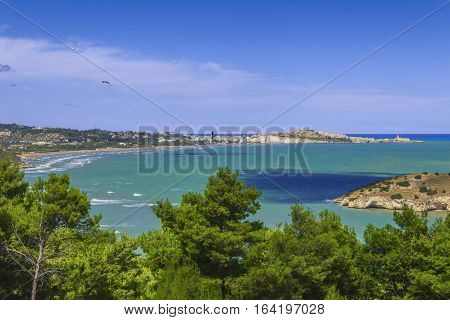 Summertime relax.The most beautiful coasts of Italy: bay of Vieste.-(Apulia, Gargano) -In the foreground the Gattarella islet and in the background Castello or Scialara beach and the town of Vieste.
