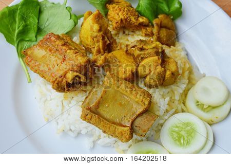 pork rib and chicken in yellow curry on plain rice