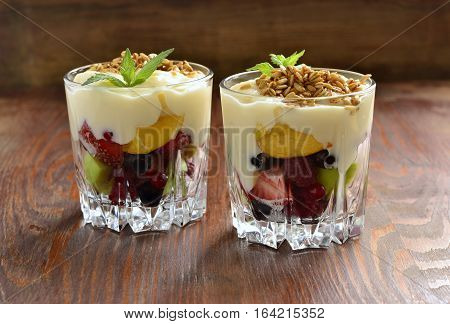 Dessert with fresh berries granola and custard in glasses