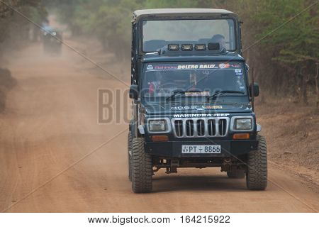 MINNERIYA, SRI LANKA. July 21, 2016: Minneriya National Park. A jeep carrying tourists visiting the famous national park of Sri Lanka. A car goes into the park in search of wild animals.