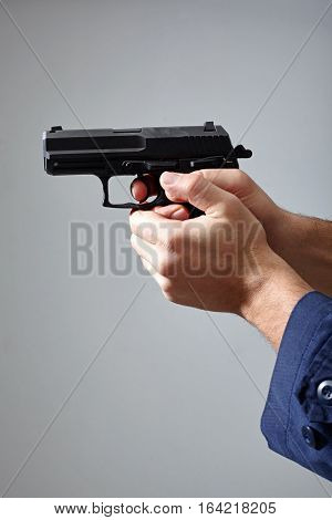 Closeup view of man's hands aiming with gun.