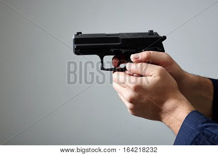 Closeup view of man's hands aiming with gun.