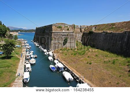 Boats in the canal under the old fortress of Corfu Greece