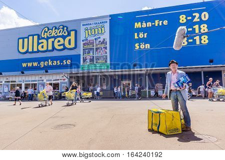 A Swedish TV-team is asking a man some questions in front of Gekås Ullared, Sweden, June 28, 2016. It is a big blue superstore that started back in 1963 is currently Sweden's most popular visitor attraction and the largest mall in Scandinavia.