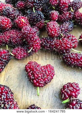 closeup ripe mulberries on a table wood