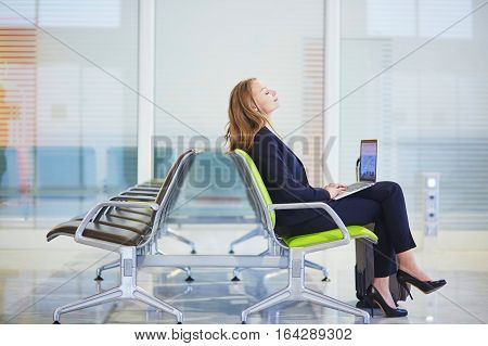 Woman In International Airport Terminal, Working On Her Laptop