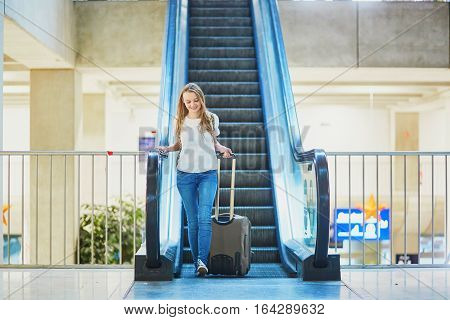 Tourist Girl With Backpack And Carry On Luggage In International Airport, On Escalator