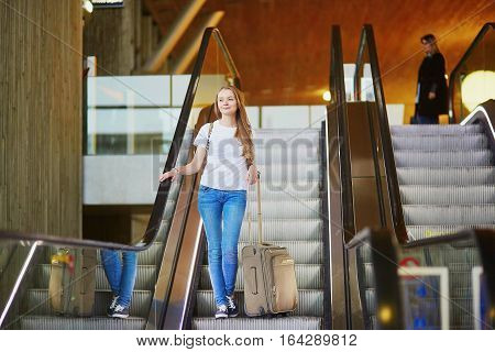 Tourist Girl With Backpack And Carry On Luggage In International Airport, On Escalator