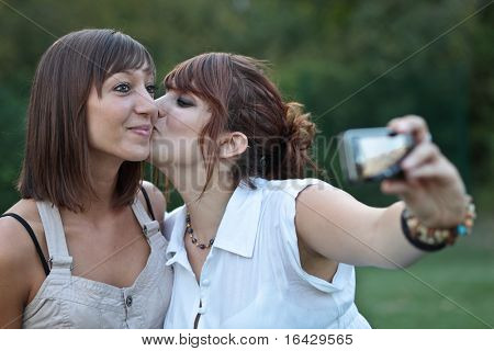 dois jovens caucasianas amigas tirar auto-retratos de se beijar, se divertindo