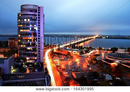 The lights of evening city view from the roof, bridge, river, skyscraper, cars, houses