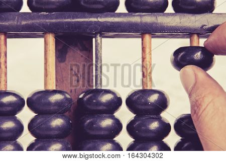 close up image of hand accounting with old abacus. financial concept