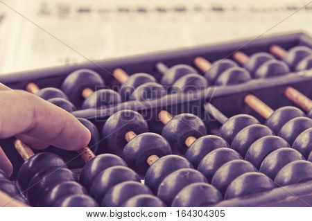 close up image of hand accounting with old abacus. financial concept