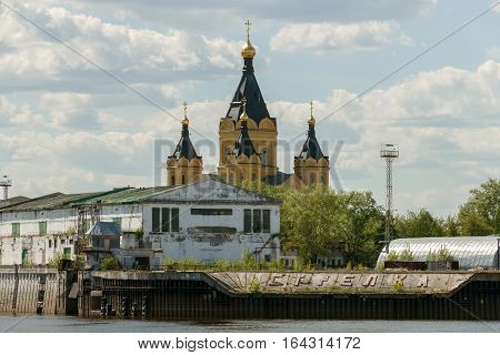 Alexander Nevsky Cathedral in Nizhny Novgorod behind the buildings of the cargo river port on the Strelka