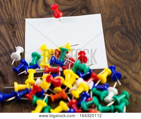 Various Color Thumbtacks And Note On Distressed Wood