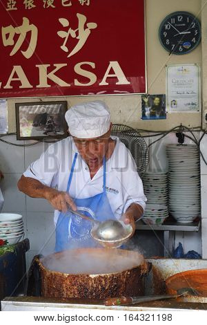 Hawker Vendor At Their Assam Laksa Noodle Stall In Air Itam, Penang