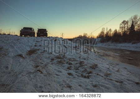 The river Tosno, Leningrad oblast, Russia - January 07, 2017, Hammer H3 and Jeep Wrangler Jk on the shore of the river, the Hummer H3 is a compact SUV produced by GM