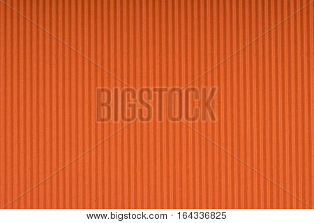 Striped embossed orange paper. Colored paper texture background