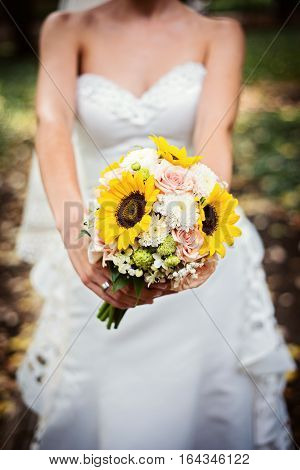 Bride holding her wedding bouquet of sunflowers