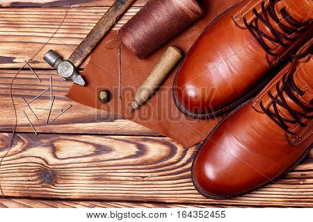 Leather Boots And Bootmaker Tools Awl, Nails, Skien Of Thread .wooden Background.concept Tools Bootm