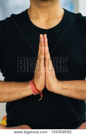 Hands in Namaste prayer mudra by Indian man practicing yoga.