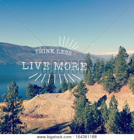 Scenic summer lake landscape with mountain road and tall trees in foreground.  Lake, clear blue sky and mountains in background with inspirational quote. 
