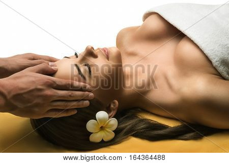 Beautiful young girl has a facial massage. Luxury spa treatment. White background