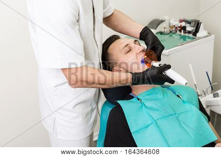 blue Dental Curing Light is used to cure the resin within a dental patient's mouth . Polymerization process