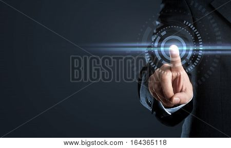 Business man touching virtual interface button on dark background with copy space