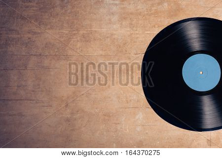vintage audiophile and musiclover set; vinyl musical disc on wooden background;