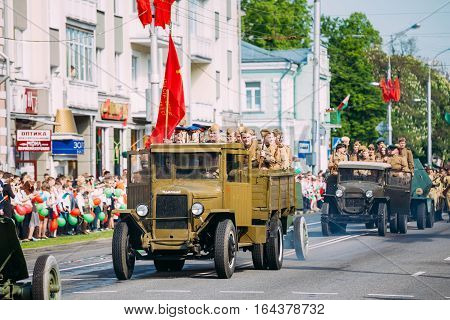 Gomel, Belarus - May 9, 2016: The Parade Of Russian Soviet Military Cars Of WW2 Time With Re-Enactors Dressed As Soldiers. The Truck ZIS-5V With Red Flag Foreground. Celebrating Victory Day Holiday