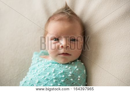 Newborn baby lies on a blanket with hairstyle Mohawk