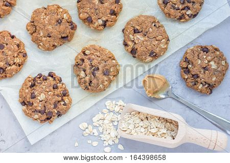 Flourless gluten free peanut butter oatmeal and chocolate chips cookies on parchment top view horizontal