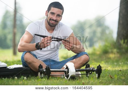 Man Tightening Propeller On Drone In Nature